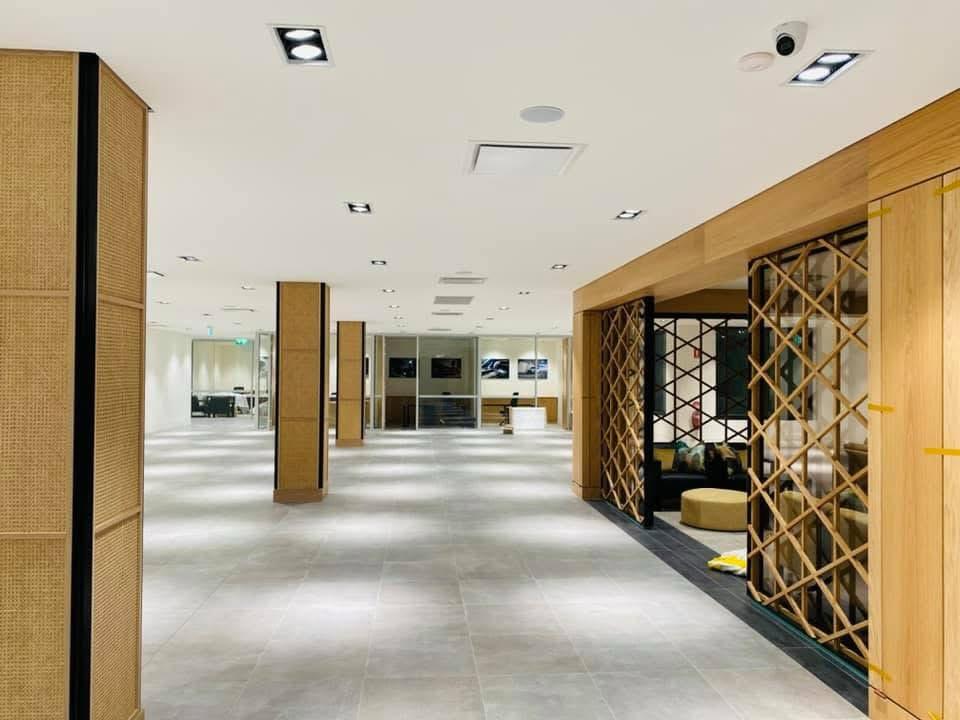 Bright office hallway featuring minimalist white wall painting and natural wood accents for a premium corporate look