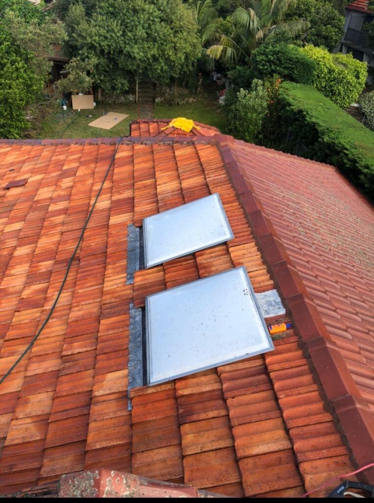 Terracotta roof tiles before restoration and painting in Sydney featuring dual skylights.